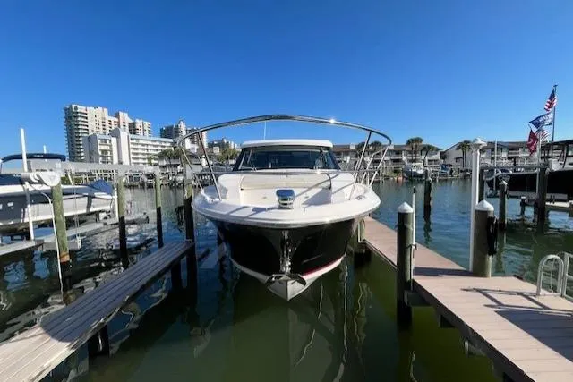 Slide: The Image of 2022 Regal 38 XO boat docked in a marina with clear blue sky. - 11