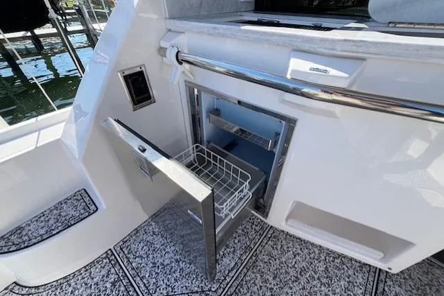 Slide: The Image of 2022 Regal 38 XO yacht with open stainless steel refrigerator in the cockpit area. - 15