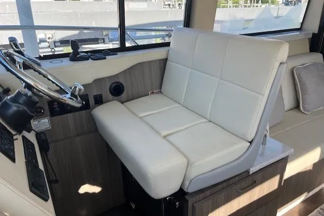 Slide: The Image of Captain's seat in 2022 Regal 38 XO boat, featuring modern design and comfortable white upholstery. - 18
