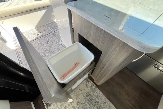 Slide: The Image of 2022 Regal 38 XO yacht interior with pull-out trash bin in modern kitchen area. - 26