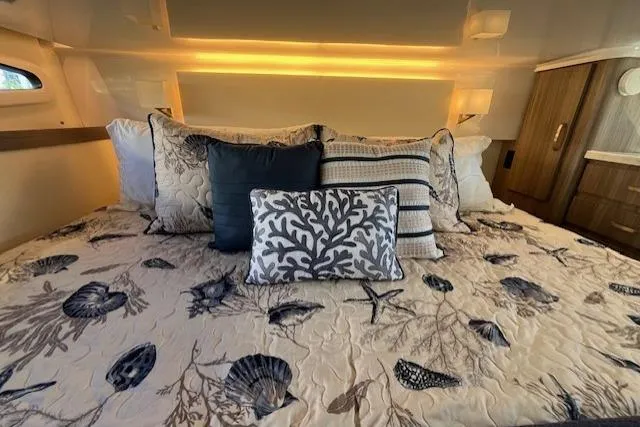 Slide: The Image of Luxurious 2022 Regal 38 XO yacht cabin with elegant bedding and ambient lighting. - 29