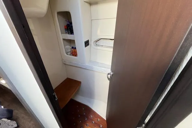 Slide: The Image of 2022 Regal 38 XO yacht interior bathroom with wooden accents and storage shelves. - 31