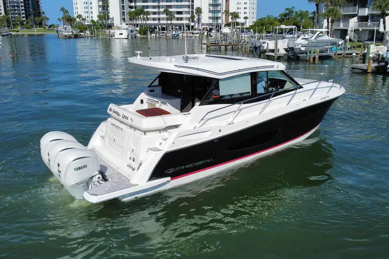 Slide: The Image of 2022 Regal 38 XO boat with Yamaha engines docked in a marina. - 4
