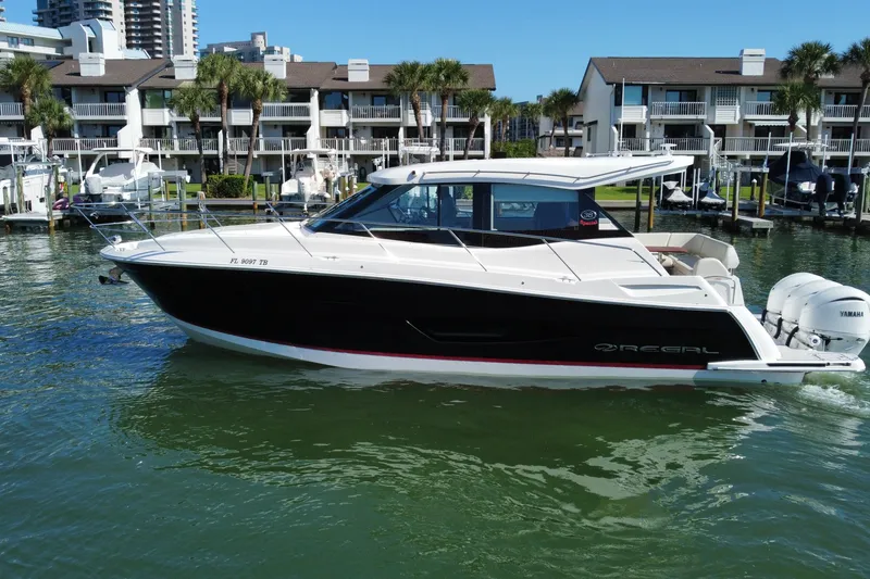 Slide: The Image of 2022 Regal 38 XO boat docked in marina with waterfront buildings. - 7