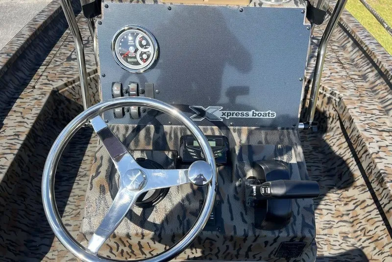 Slide: The Image of Steering console of 2026 Xpress H20 boat with camo design and control panel. - 12