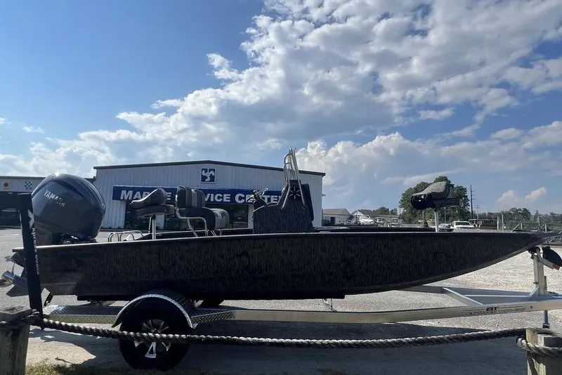 Slide: The Image of 2026 Xpress H20 boat on trailer at marine service center under cloudy sky. - 4