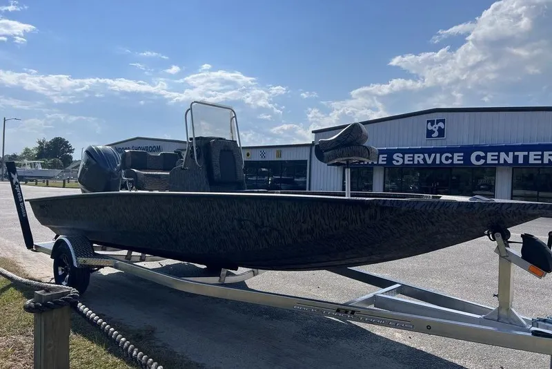 Slide: The Image of 2026 Xpress H20 boat on trailer outside service center under blue sky. - 5