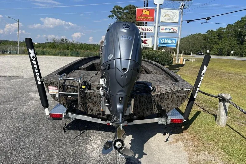 Slide: The Image of 2026 Xpress H20 boat with Yamaha engine, parked outdoors near dealership signs. - 9