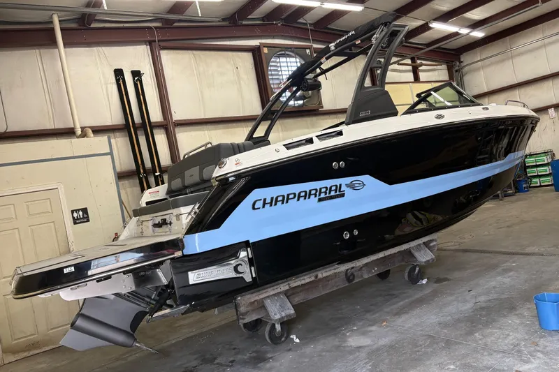 The Image of 2025 Chaparral 26 Surf boat in a workshop, showcasing sleek design and modern features. - 0