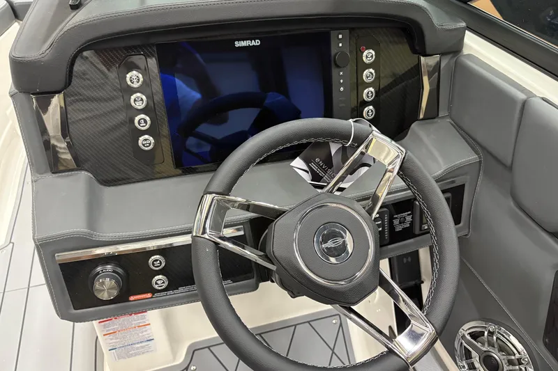 Slide: The Image of 2025 Chaparral 26 Surf boat dashboard with steering wheel and Simrad display. - 10