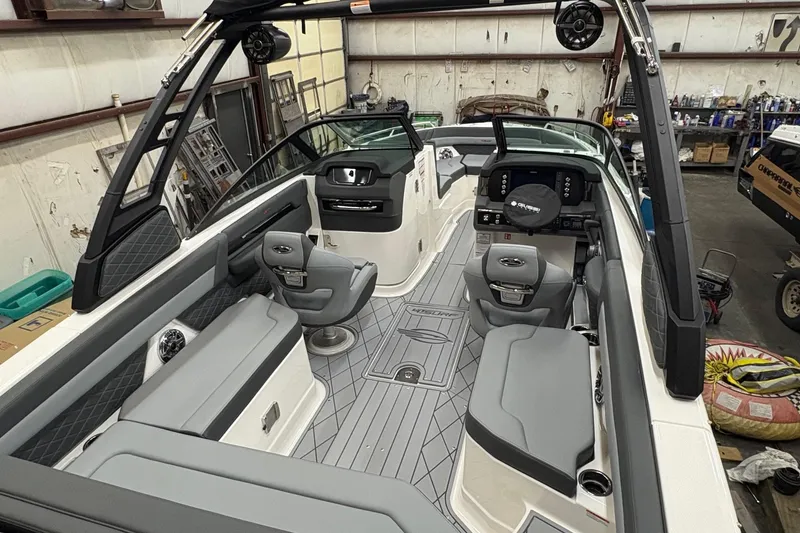 Slide: The Image of 2025 Chaparral 26 Surf boat interior with modern seating and sleek design in a workshop. - 4
