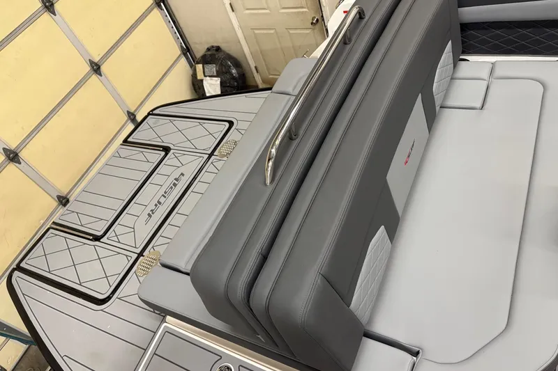 Slide: The Image of 2025 Chaparral 26 Surf boat interior with sleek gray seating and stylish deck design. - 7