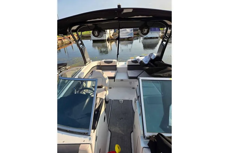 Slide: The Image of 2017 Chaparral Vortex 203 VR boat interior at a dock, featuring seating and open windshield. - 12