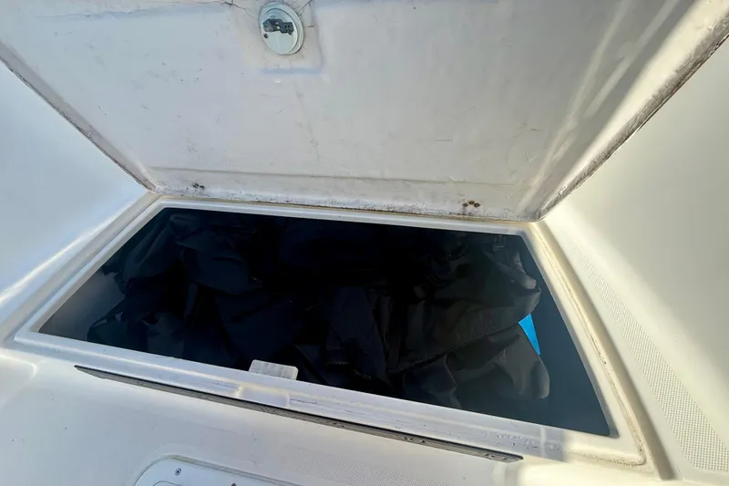 Slide: The Image of Open storage compartment on 2001 Aquasport 205 Osprey boat, containing dark fabric. - 15