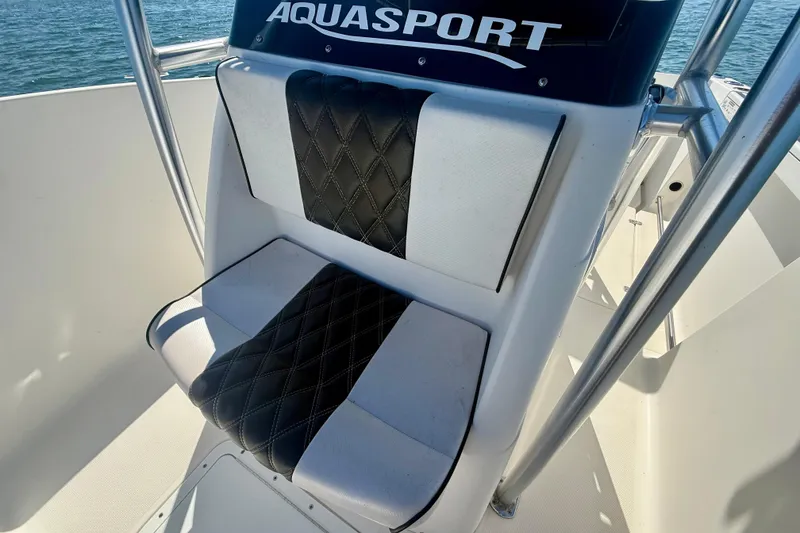Slide: The Image of 2001 Aquasport 205 Osprey boat seat with black and white upholstery, ocean background. - 17