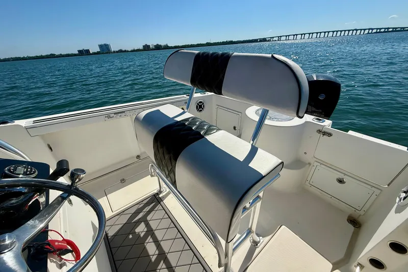 Slide: The Image of 2001 Aquasport 205 Osprey boat interior with seating, steering wheel, and ocean view. - 19