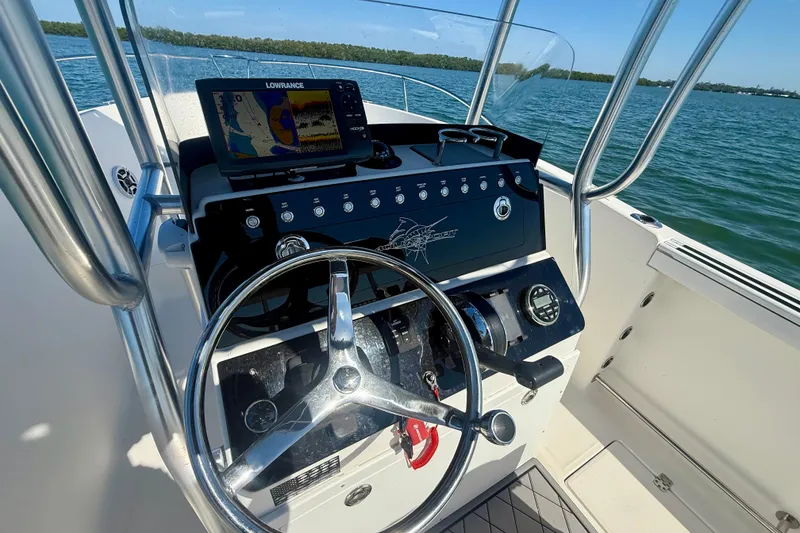 Slide: The Image of 2001 Aquasport 205 Osprey boat dashboard with steering wheel and navigation system. - 20