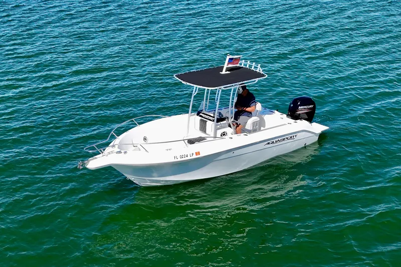 Slide: The Image of 2001 Aquasport 205 Osprey boat on clear blue water, featuring a Mercury engine. - 5