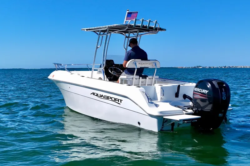 Slide: The Image of 2001 Aquasport 205 Osprey boat on water, featuring Mercury 150 engine, clear blue sky. - 7