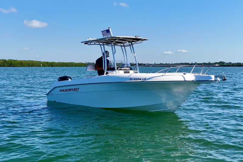 Slide: The Image of 2001 Aquasport 205 Osprey boat on calm water under clear blue sky. - 9