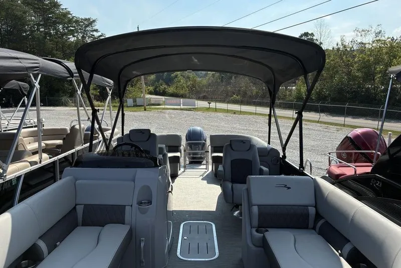 Slide: The Image of 2022 Bennington 22 LFB pontoon boat with spacious seating and canopy, parked outdoors. - 2