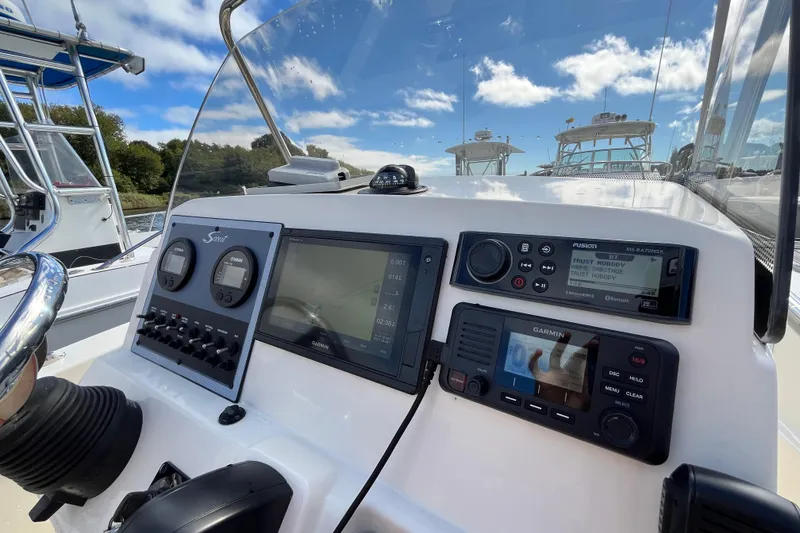 Slide: The Image of 2020 Scout 195 Sportfish dashboard with navigation and control systems under a clear sky. - 10