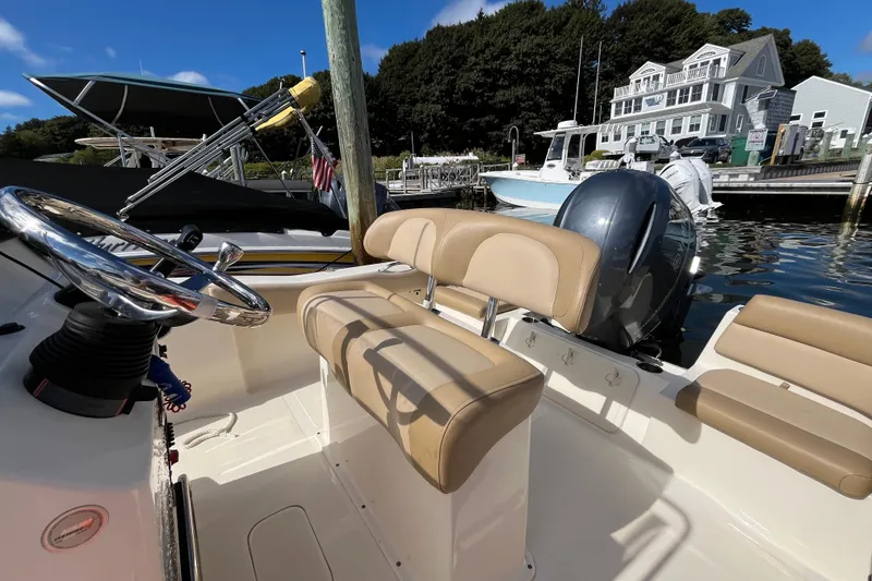 Slide: The Image of 2020 Scout 195 Sportfish boat with tan seating, docked near a marina. - 18