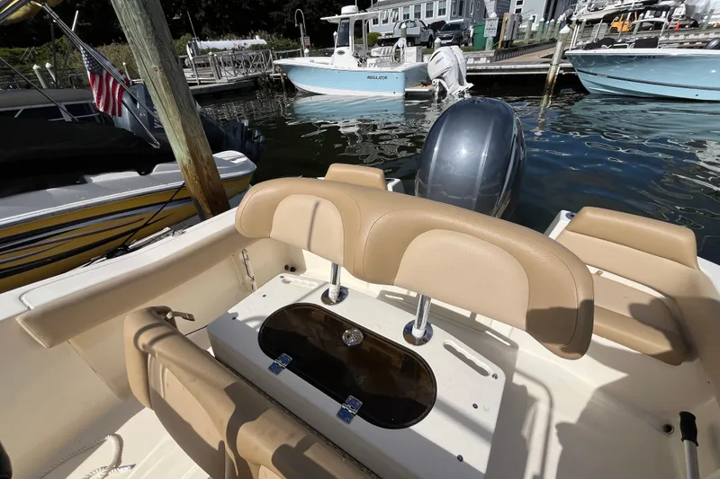 Slide: The Image of 2020 Scout 195 Sportfish boat interior with seating and outboard motor at dock. - 19