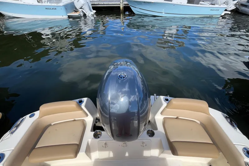 Slide: The Image of 2020 Scout 195 Sportfish boat with Yamaha outboard engine, docked near other boats. - 23