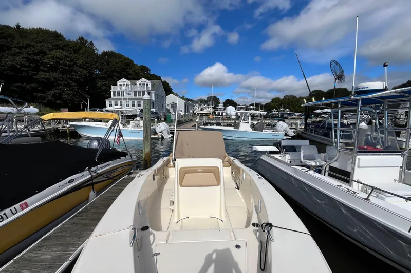 Slide: The Image of 2020 Scout 195 Sportfish boat docked at a marina under a blue sky. - 38