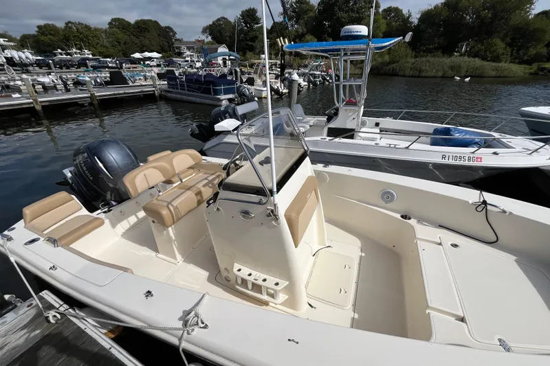 Slide: The Image of 2020 Scout 195 Sportfish boat docked, featuring beige seating and a Yamaha outboard motor. - 5
