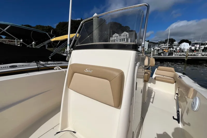 Slide: The Image of 2020 Scout 195 Sportfish boat with tan seating, docked at a marina under blue skies. - 8