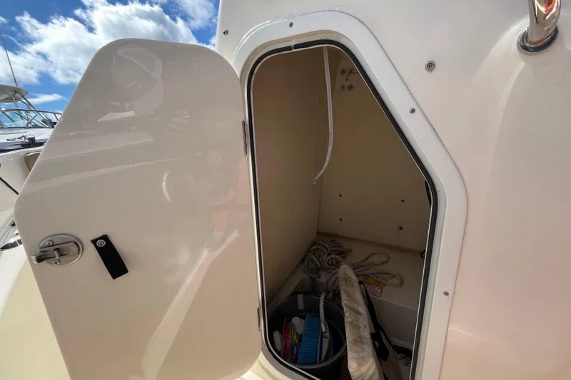 Slide: The Image of Open storage compartment on 2020 Scout 195 Sportfish boat under a clear blue sky. - 9