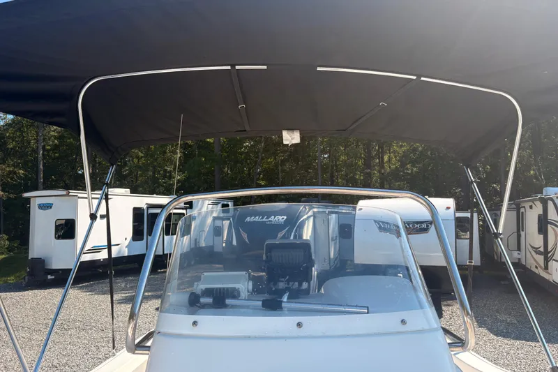 Slide: The Image of 2015 Tidewater 198 CC Adventure boat with canopy, parked near RVs. - 19