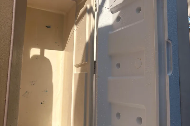 Slide: The Image of 2015 Tidewater 198 CC Adventure boat storage compartment interior with sunlight and shadows. - 26