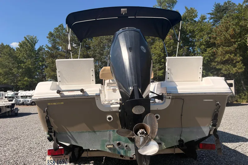 Slide: The Image of 2015 Tidewater 198 CC Adventure boat with outboard motor, parked on gravel lot. - 8