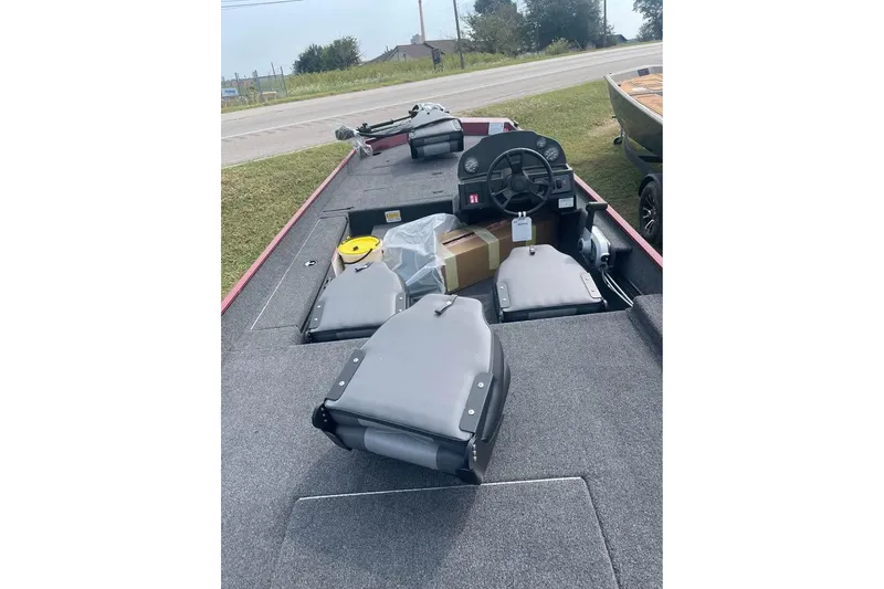 Slide: The Image of 2026 Lowe Skorpion 17 boat interior with steering wheel and seating, parked near a road. - 6