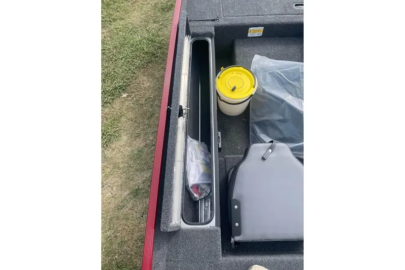 Slide: The Image of 2026 Lowe Skorpion 17 boat storage compartment with fishing gear and bucket. - 8