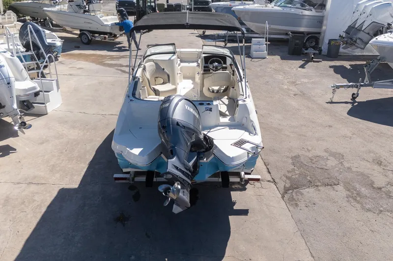 Slide: The Image of 2024 Stingray 211DC boat with Yamaha outboard motor, parked in a marina. - 15