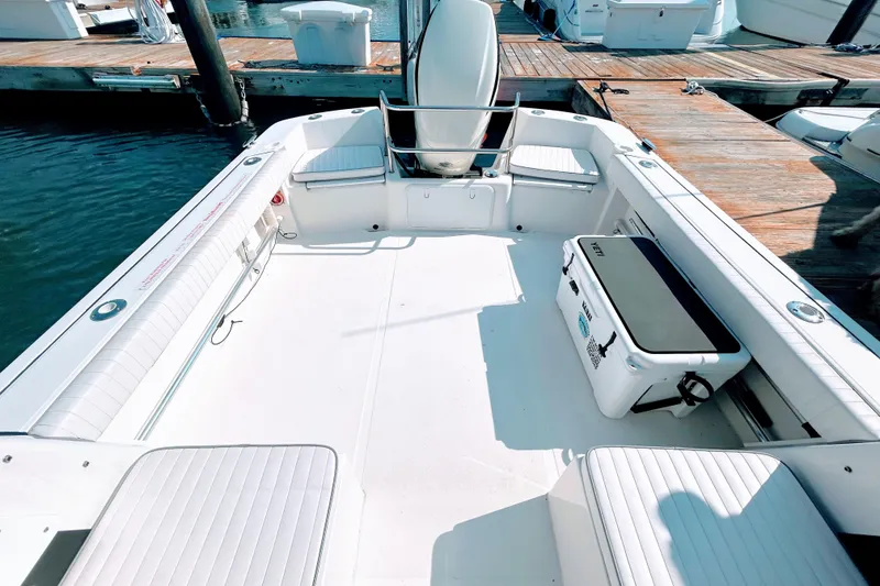 Slide: The Image of 2020 Maritime 23 Challenger boat interior with seating and cooler at dock. - 15