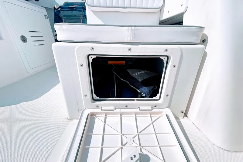 Slide: The Image of Storage compartment on a 2020 Maritime 23 Challenger boat, featuring cushioned seating. - 16