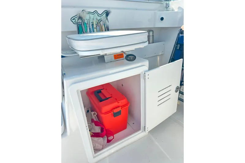 Slide: The Image of Open storage compartment on 2020 Maritime 23 Challenger boat with red toolbox inside. - 17