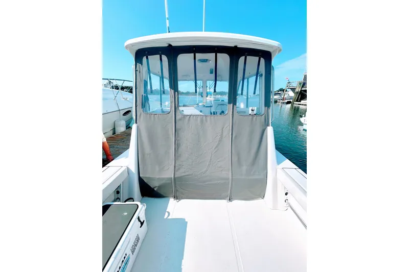 Slide: The Image of 2020 Maritime 23 Challenger boat with enclosed cabin, docked at marina under clear blue sky. - 21