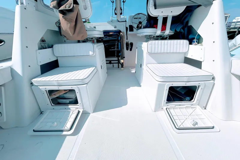 Slide: The Image of 2020 Maritime 23 Challenger boat interior with white seating and storage compartments. - 25