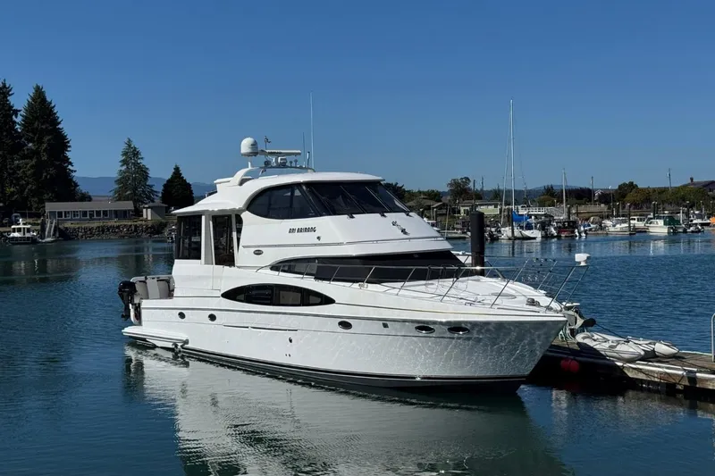 The Image of 2004 Carver 564 Cockpit Motor Yacht docked in a serene marina setting. - 0