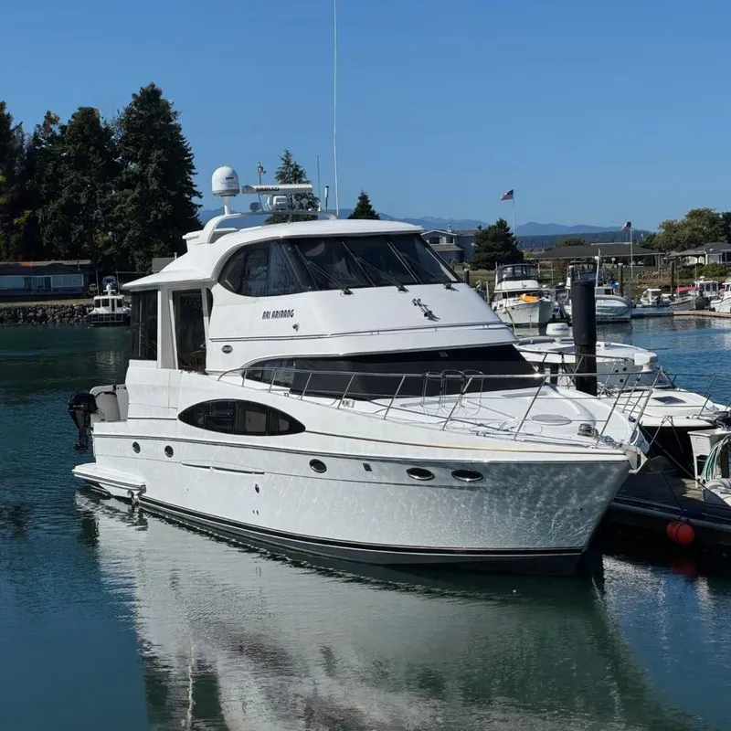 Slide: The Image of 2004 Carver 564 Cockpit Motor Yacht docked in a marina, surrounded by other boats. - 1