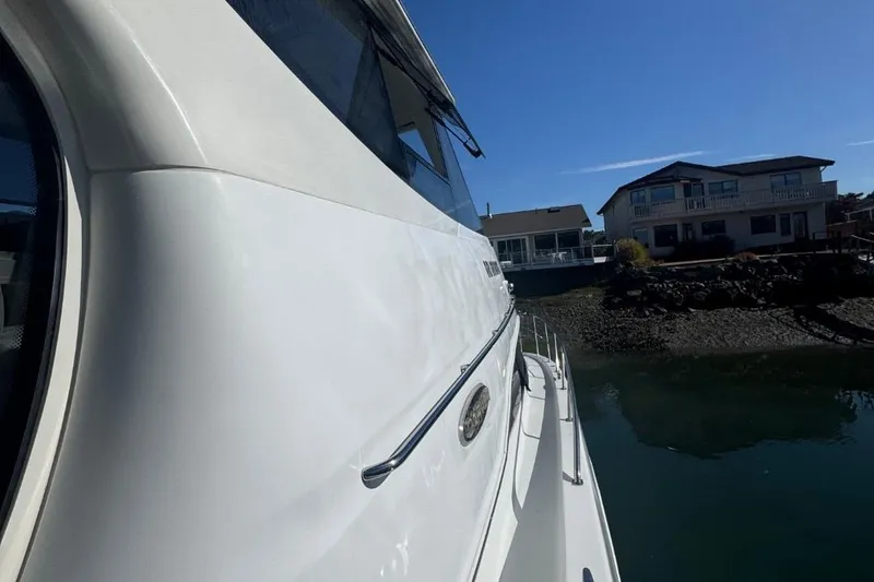 Slide: The Image of 2004 Carver 564 Cockpit Motor Yacht docked near waterfront homes. - 10