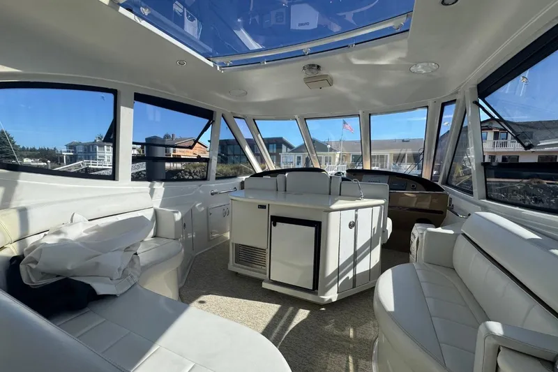 Slide: The Image of Interior of 2004 Carver 564 Cockpit Motor Yacht with spacious seating and panoramic windows. - 12