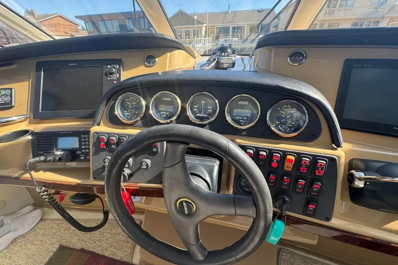 Slide: The Image of 2004 Carver 564 Cockpit Motor Yacht helm with steering wheel and control panels. - 16