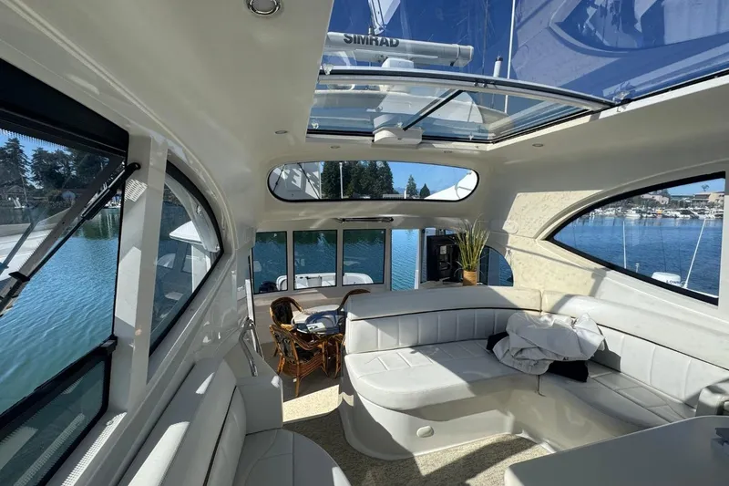 Slide: The Image of Luxurious interior of 2004 Carver 564 Cockpit Motor Yacht with panoramic windows and plush seating. - 23